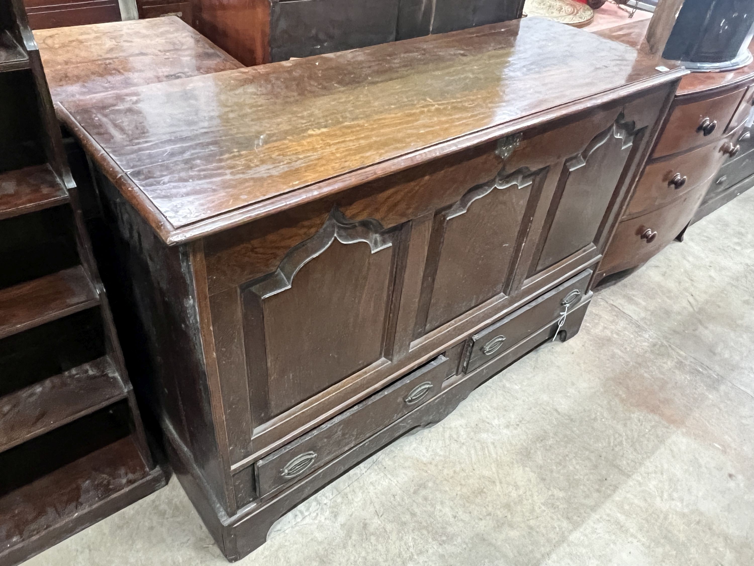 A mid 18th century oak mule chest with arched triple panelled front, width 144cm, depth 51cm, height 97cm